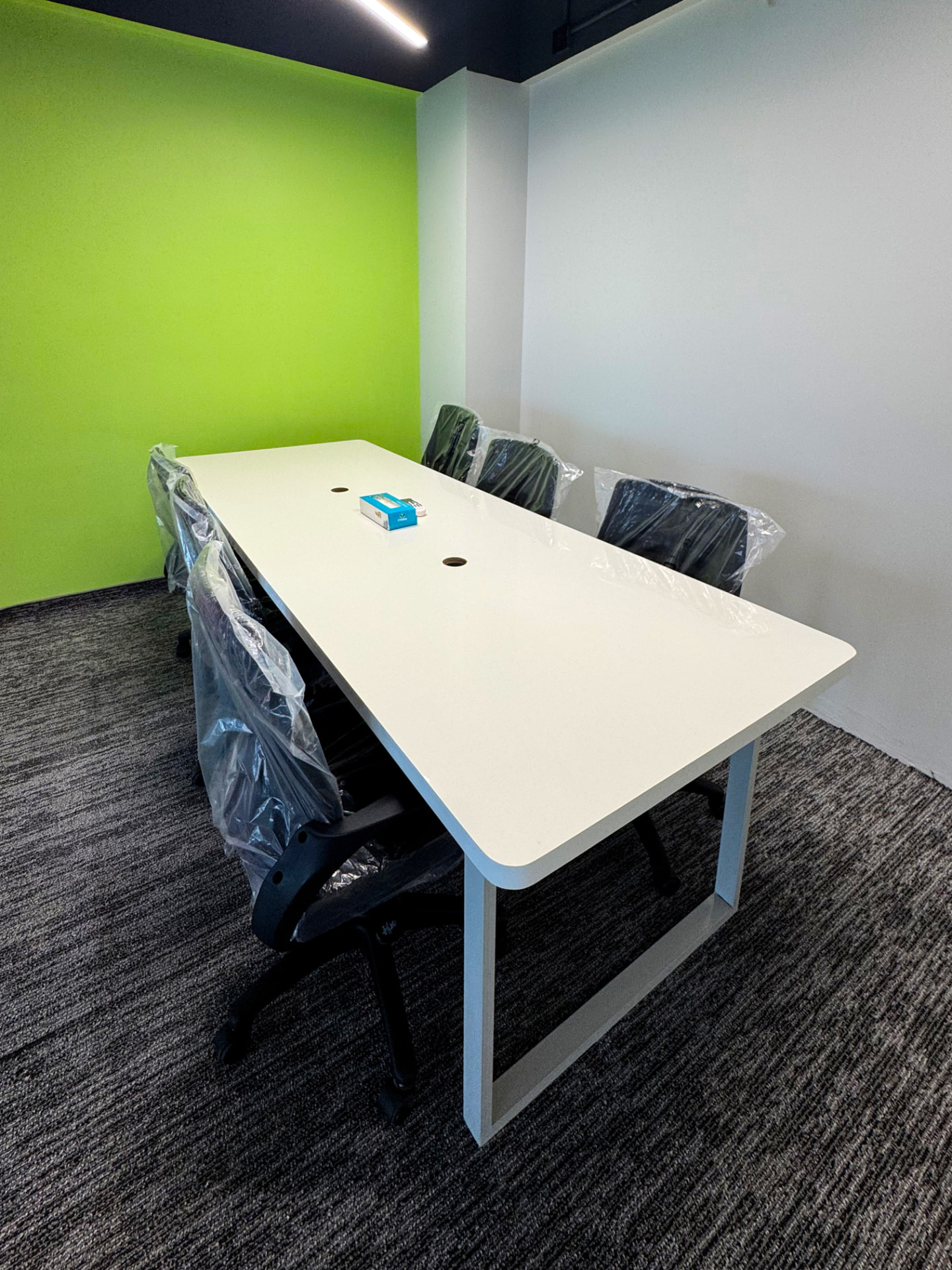 Meeting room with lime green accent wall at WorkMore, The Pavilion Karachi
