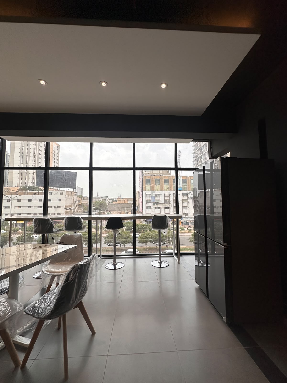 Café corner with bar stools and city view at WorkMore, The Pavilion