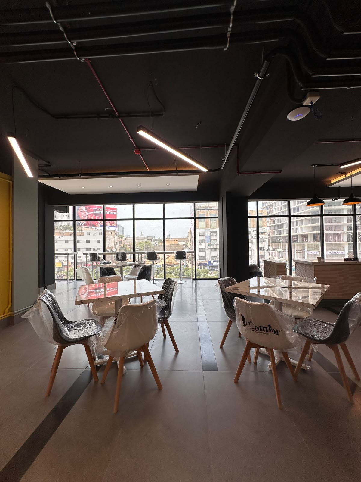 Café-style seating and communal tables at WorkMore, The Pavilion Karachi