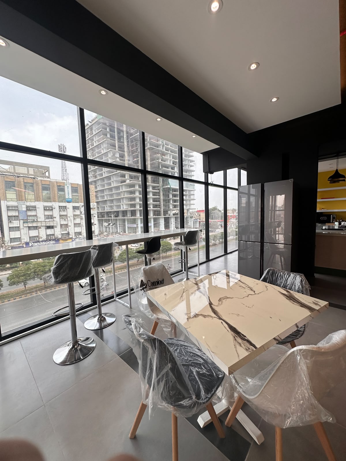 WorkMore The Pavilion lounge with floor-to-ceiling windows overlooking Shahrah-e-Faisal, Karachi